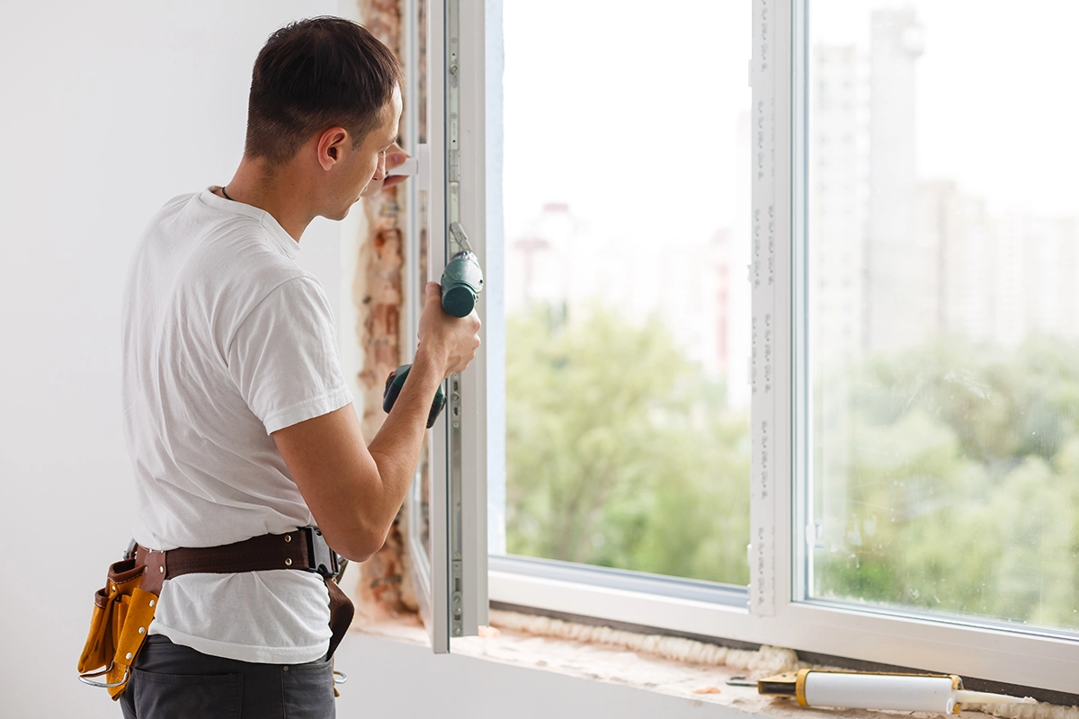 young handyman repair window with screwdriver